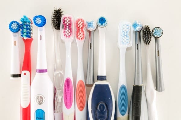 Collection of electric toothbrushes and dental care tools arranged in organized rows on white background.