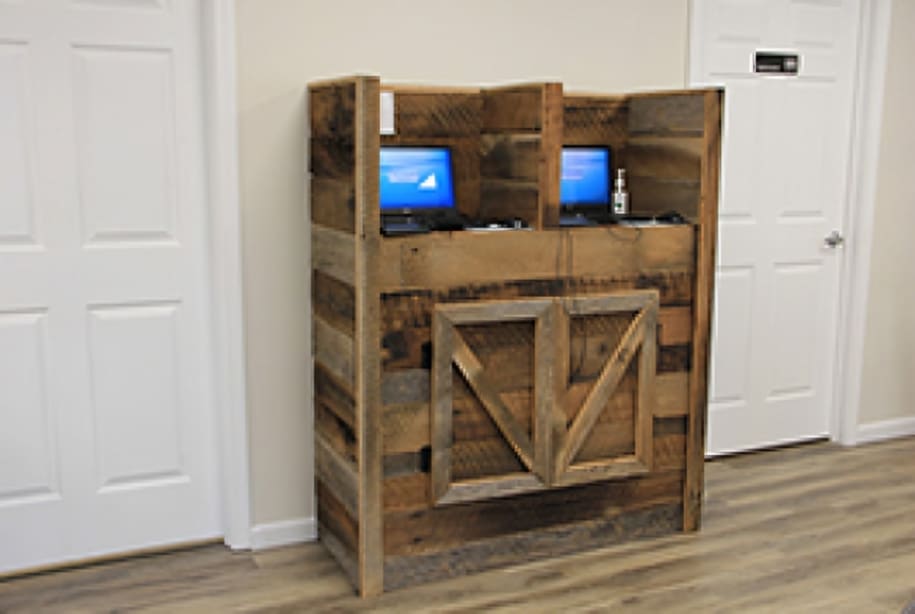 Rustic wooden cabinet with barn doors and blue monitors in dental office hallway