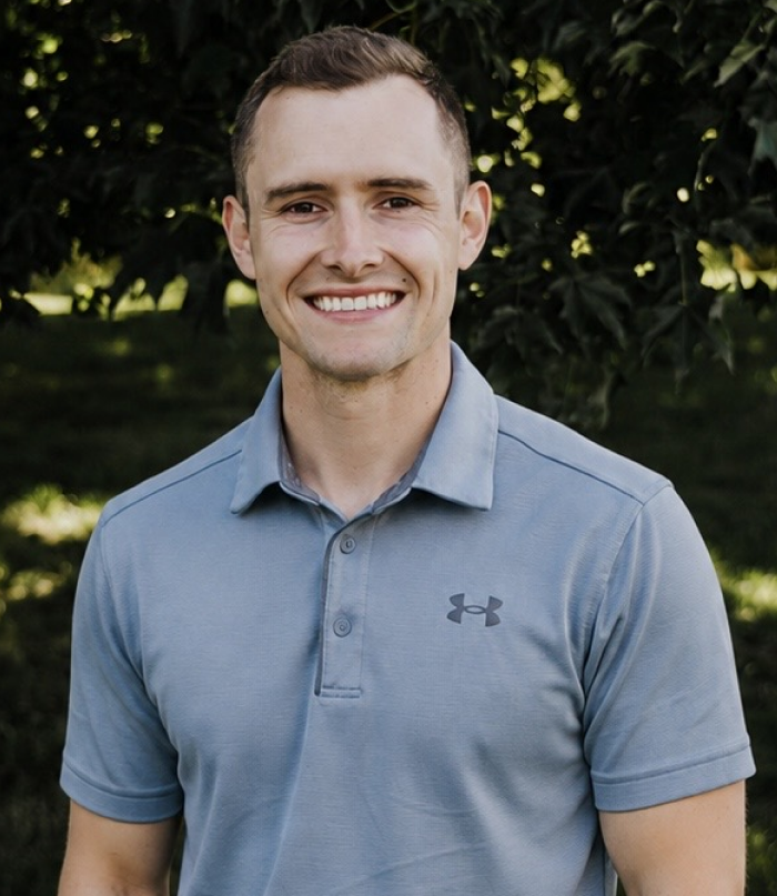 Portrait of Dr. Daniel Clark outdoors wearing a casual grey polo shirt.